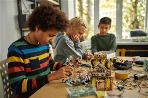 Three pre-teens building robots